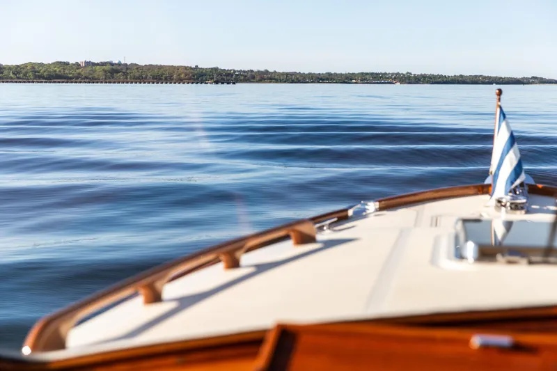 Slide: The Image of 2022 Hinckley Picnic Boat 34 S cruising on calm water, American flag displayed. - 5