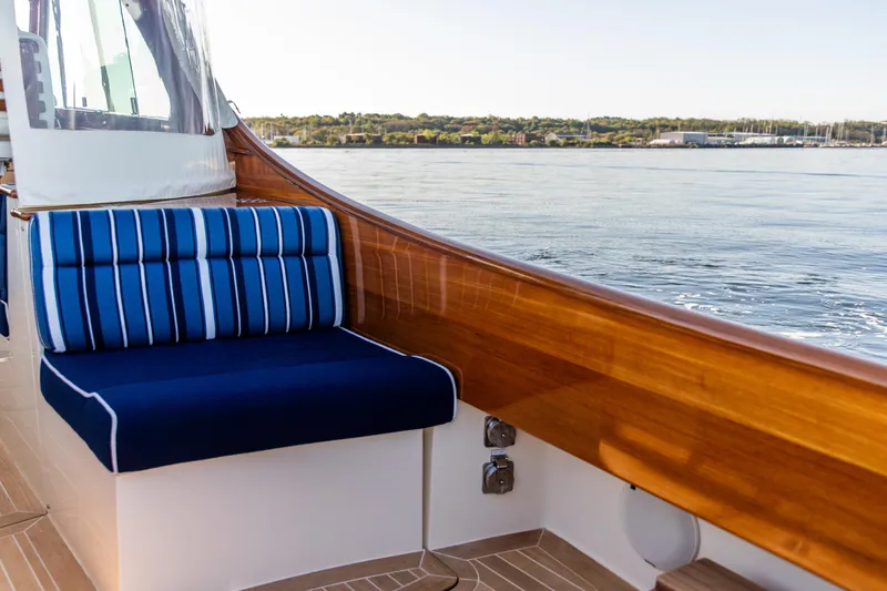 Slide: The Image of 2022 Hinckley Picnic Boat 34 S, elegant design with wood accents, docked by the water. - 8