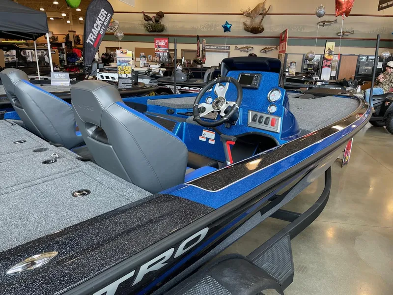 Slide: The Image of 2025 Nitro Z19 boat with blue and black detailing on display in a showroom. - 3