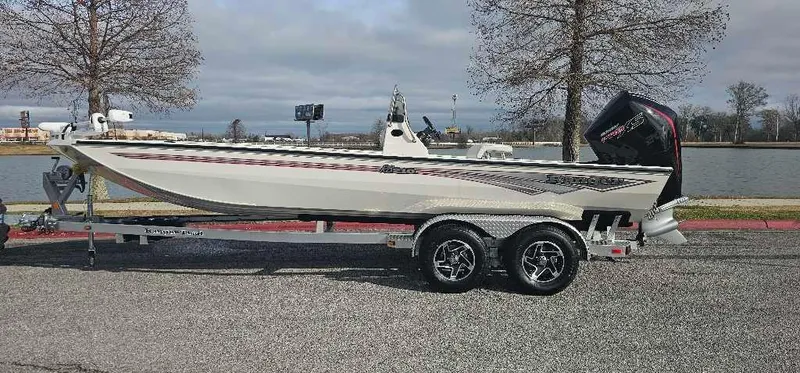 The Image of 2025 Ranger RB210 boat on trailer by a lake, featuring sleek design and powerful engine. - 0