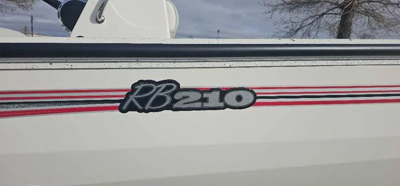 Slide: The Image of 2025 Ranger RB210 boat with red and black stripes on the side. - 2
