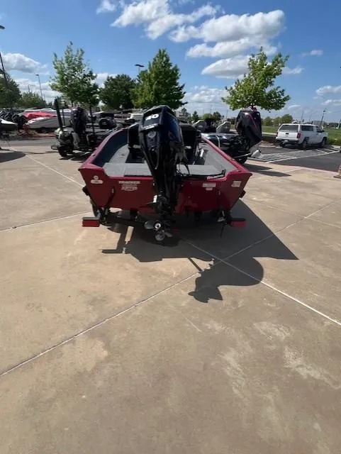 Slide: The Image of 2025 Tracker Super Guide V-16 SC boat, red, parked outdoors on a sunny day. - 2
