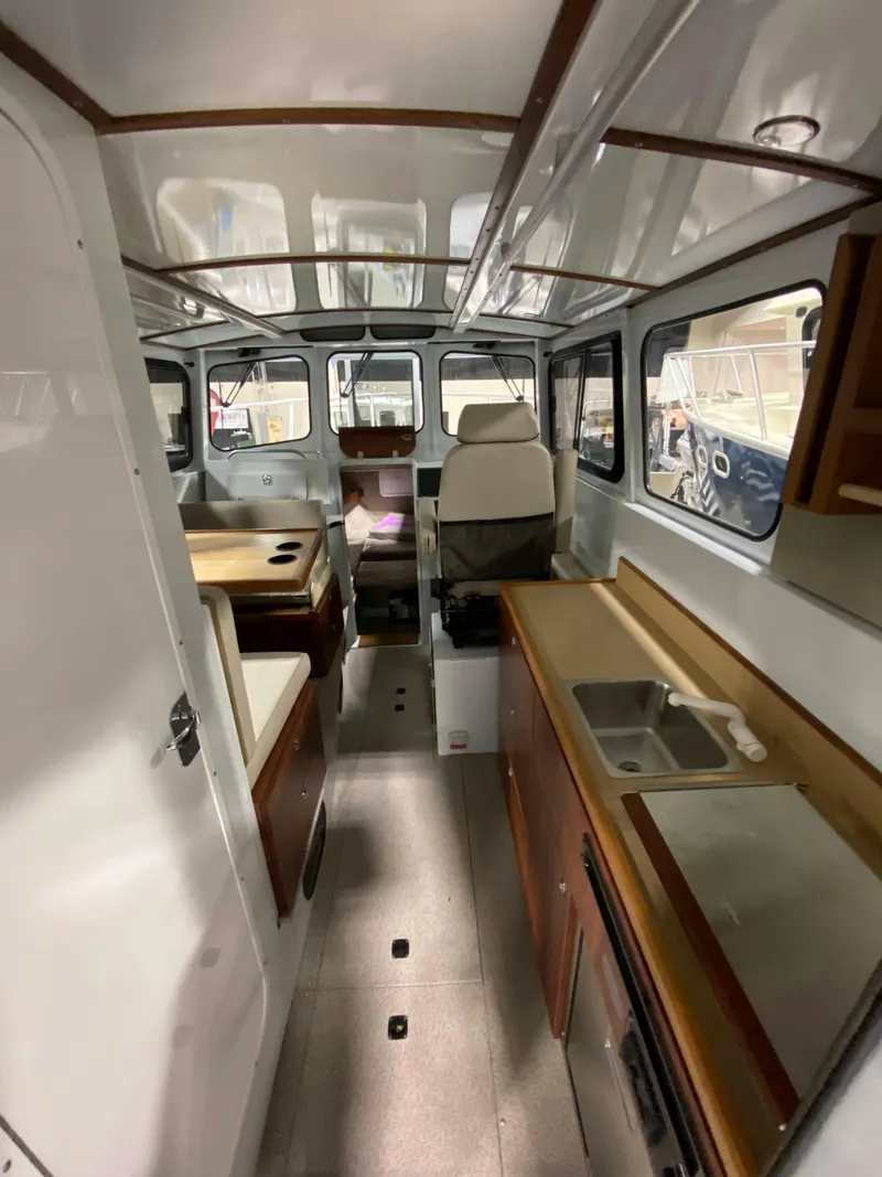 Slide: The Image of Interior of 2025 Hewescraft 270 Pacific Explorer ET HT, featuring modern kitchen and seating area. - 6