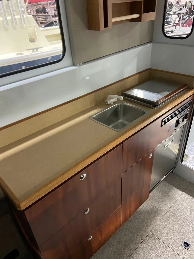 Slide: The Image of 2025 Hewescraft 270 Pacific Explorer ET HT interior kitchen with sink, countertop, and storage cabinets. - 7