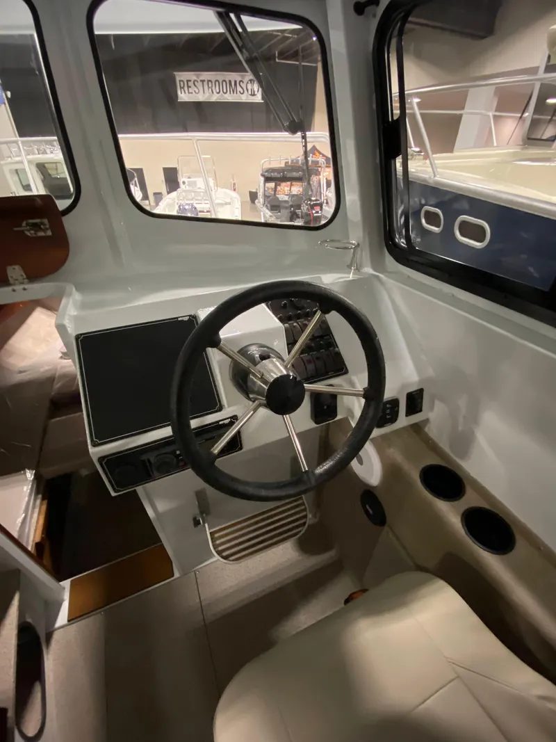 Slide: The Image of 2025 Hewescraft 270 Pacific Explorer ET HT interior helm with steering wheel and controls. - 8