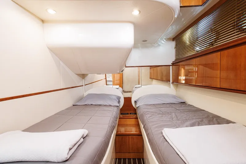 Slide: The Image of 2008 Pershing 50 yacht cabin with twin beds and modern wood paneling. - 13