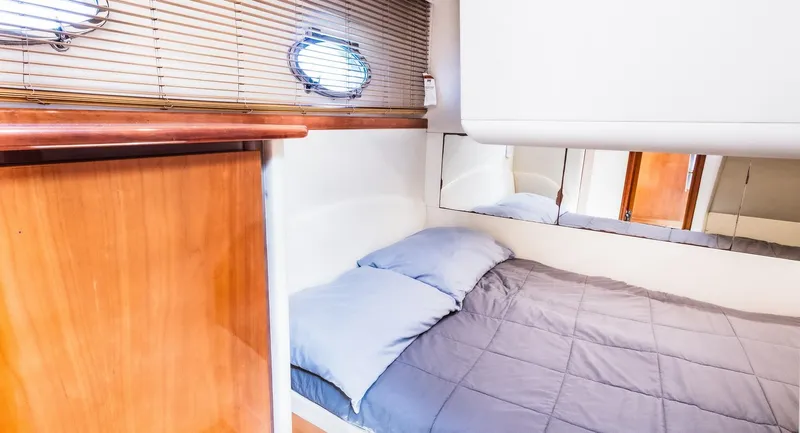 Slide: The Image of 2008 Pershing 50 yacht cabin with bed, wooden accents, and porthole window. - 18