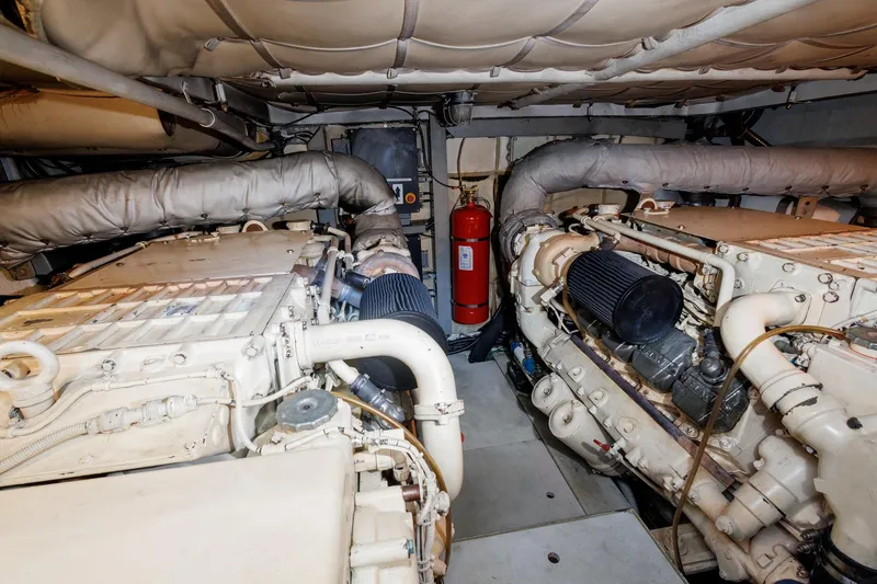 Slide: The Image of Engine room of a 2008 Pershing 50 yacht, featuring dual engines and a fire extinguisher. - 22