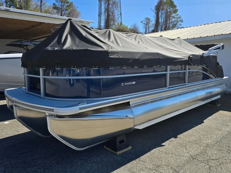 The Image of 2025 Harris Cruiser 230 pontoon boat covered, parked outdoors. - 0