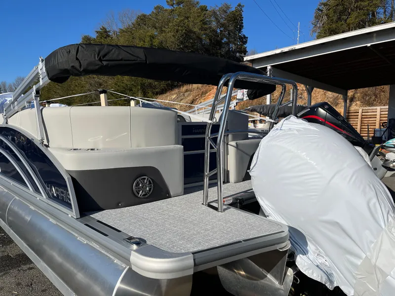 Slide: The Image of 2025 Harris Cruiser 230 pontoon boat with covered engine, docked outdoors. - 8