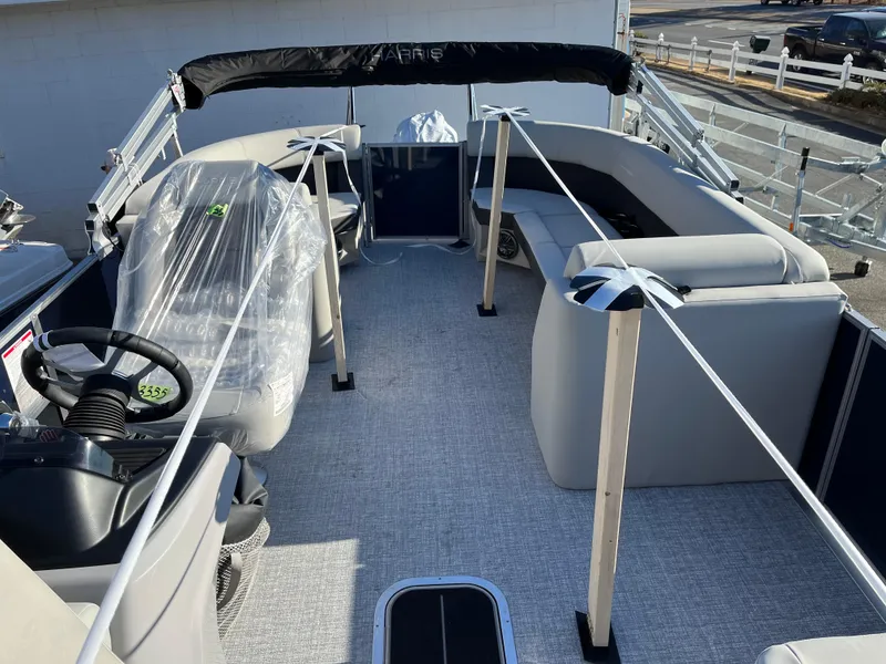 Slide: The Image of 2025 Harris Cruiser 230 pontoon boat interior with seating and steering wheel. - 9