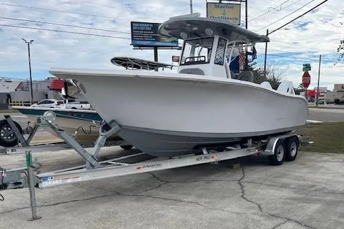 The Image of 2024 Sea Pro 262 Deluxe CC boat on trailer, parked outdoors. - 1