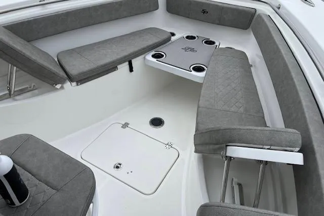 Slide: The Image of 2024 Sea Pro 262 Deluxe CC boat interior with gray seating and cup holders. - 10