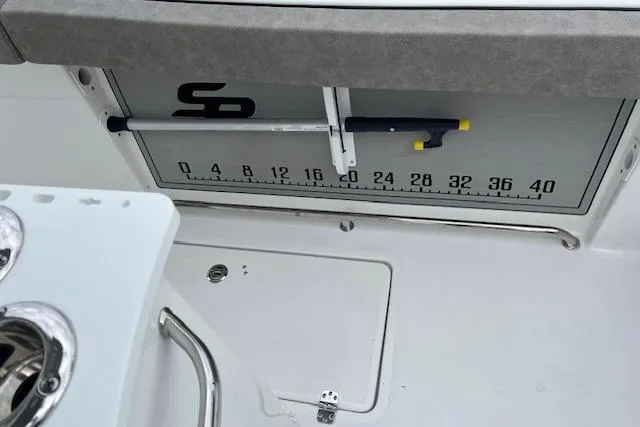 Slide: The Image of 2024 Sea Pro 262 Deluxe CC boat interior with measuring scale and storage compartment. - 14