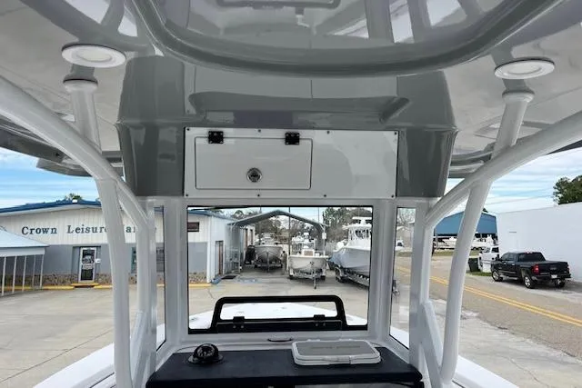 Slide: The Image of 2024 Sea Pro 262 Deluxe CC boat interior with overhead storage and dashboard view. - 6
