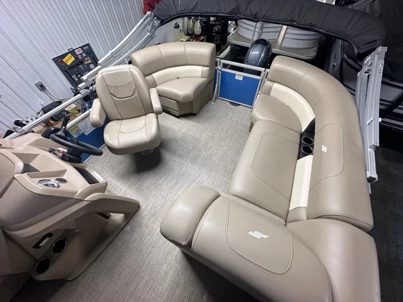 Slide: The Image of 2022 Starcraft LX 18 R boat interior with beige seating and steering console. - 2