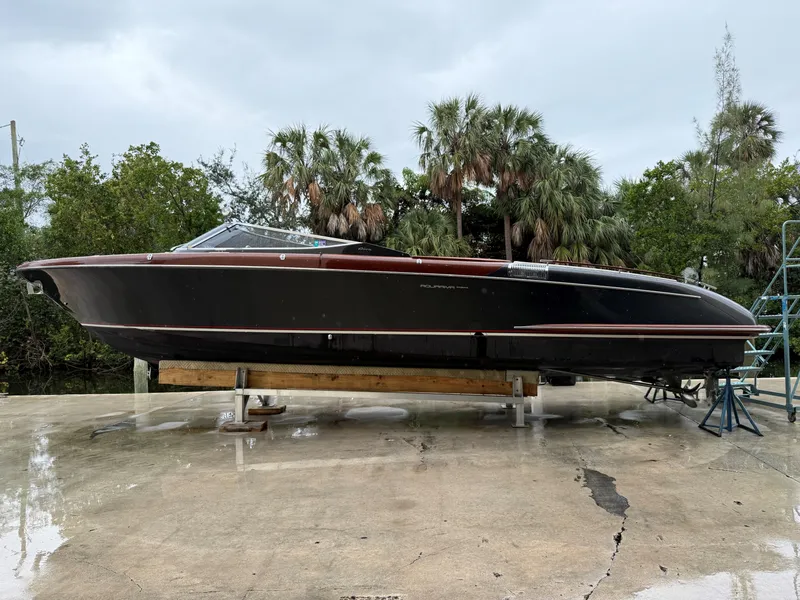 Slide: The Image of 2016 Riva Aquariva Super boat on dry dock, surrounded by lush greenery. - 1