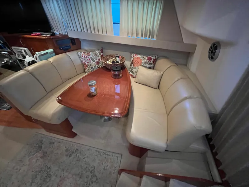 Slide: The Image of 2005 Carver 36 Mariner interior with beige leather seating and wooden table. - 11