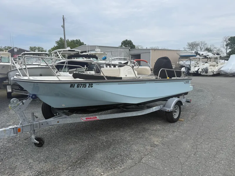 Slide: The Image of 2023 Boston Whaler 170 Montauk boat on trailer in a marina parking lot. - 2