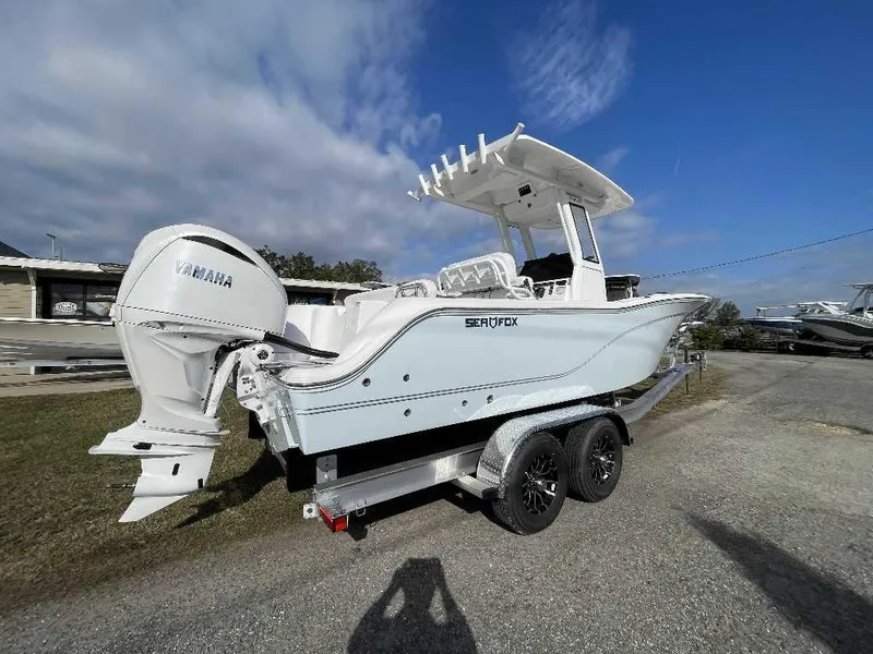 Slide: The Image of 2025 Sea Fox 248 Commander boat on trailer with Yamaha engine, under clear blue sky. - 12