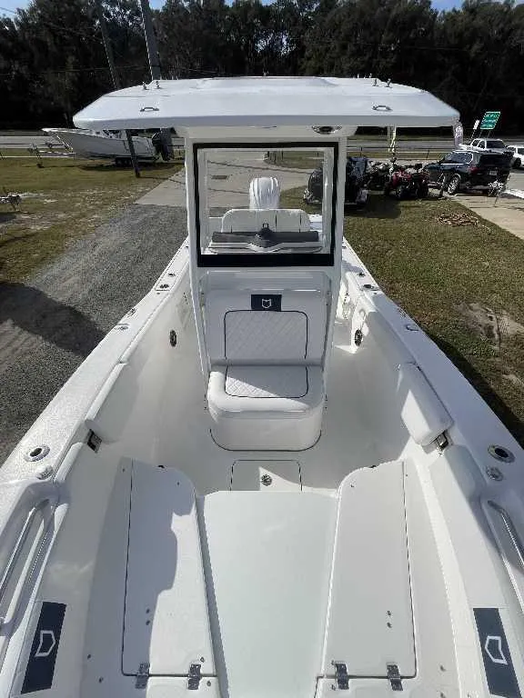 Slide: The Image of 2025 Sea Fox 248 Commander boat interior with seating and console, parked outdoors. - 6