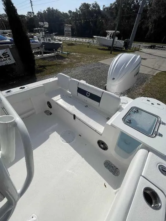 Slide: The Image of 2025 Sea Fox 248 Commander boat interior with seating and motor, parked outdoors. - 9