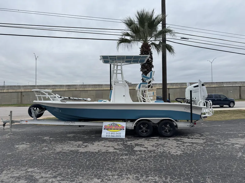The Image of 2025 Shallow Sport 24 Modified V boat on trailer, parked outdoors. - 1