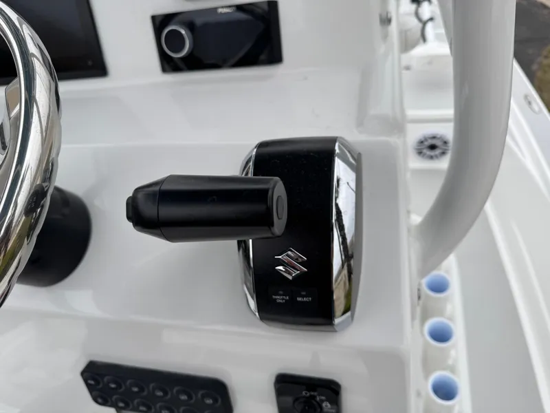 Slide: The Image of Close-up of a 2025 Shallow Sport 24 Modified V boat control panel with Suzuki throttle. - 18