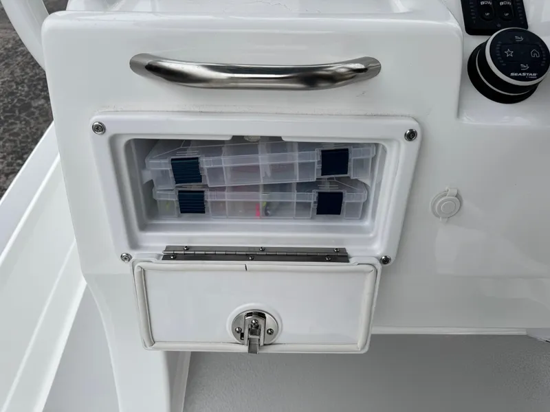 Slide: The Image of 2025 Shallow Sport 24 Modified V boat storage compartment with tackle boxes. - 20