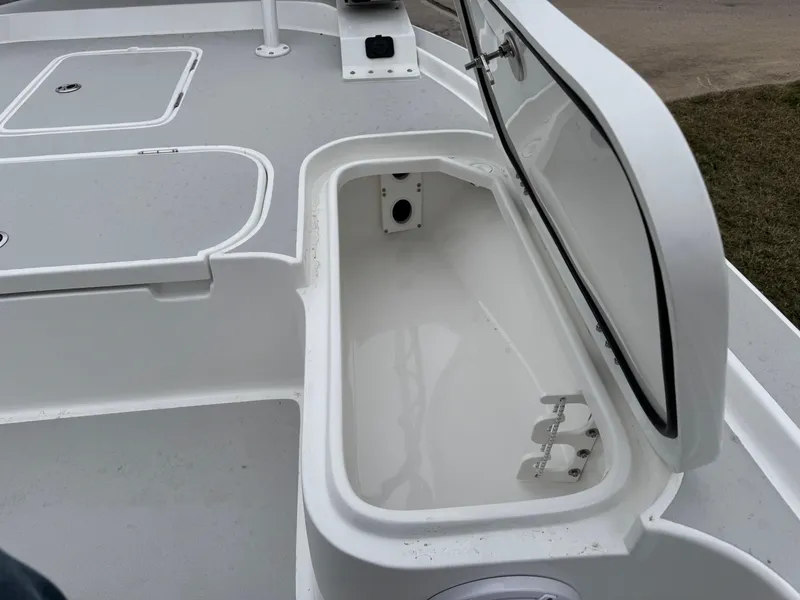 Slide: The Image of 2025 Shallow Sport 24 Modified V boat storage compartment, open lid, white interior. - 37