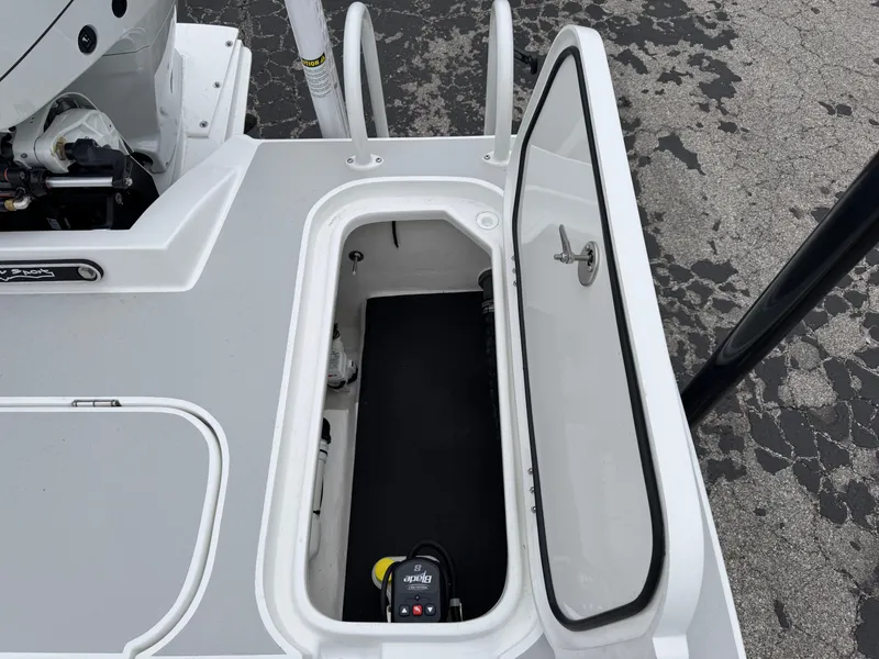 Slide: The Image of 2025 Shallow Sport 24 Modified V boat storage compartment with open hatch. - 40