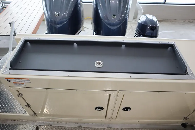Slide: The Image of 2025 Hewescraft 290 Adventure ET HT boat storage compartment with dual outboard motors. - 10