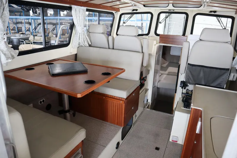 Slide: The Image of Interior of 2025 Hewescraft 290 Adventure ET HT, featuring seating and a wooden table. - 16