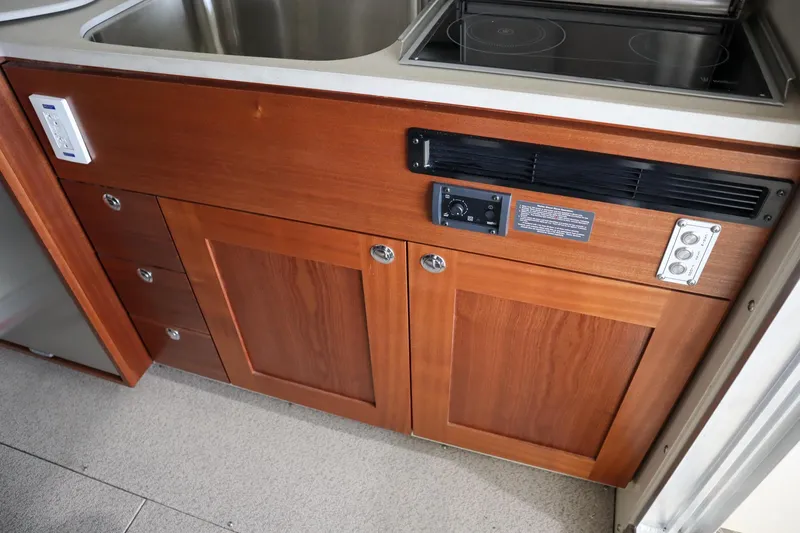 Slide: The Image of 2025 Hewescraft 290 Adventure ET HT kitchen area with wooden cabinetry and modern appliances. - 18