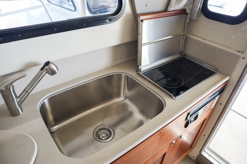 Slide: The Image of 2025 Hewescraft 290 Adventure ET HT kitchen with sink and stove. - 21