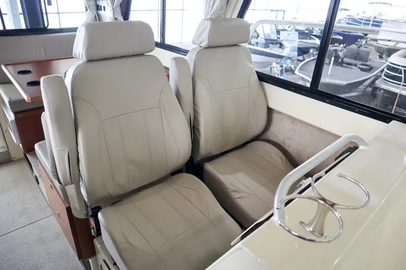 Slide: The Image of 2025 Hewescraft 290 Adventure ET HT interior with beige seating and cup holders. - 24