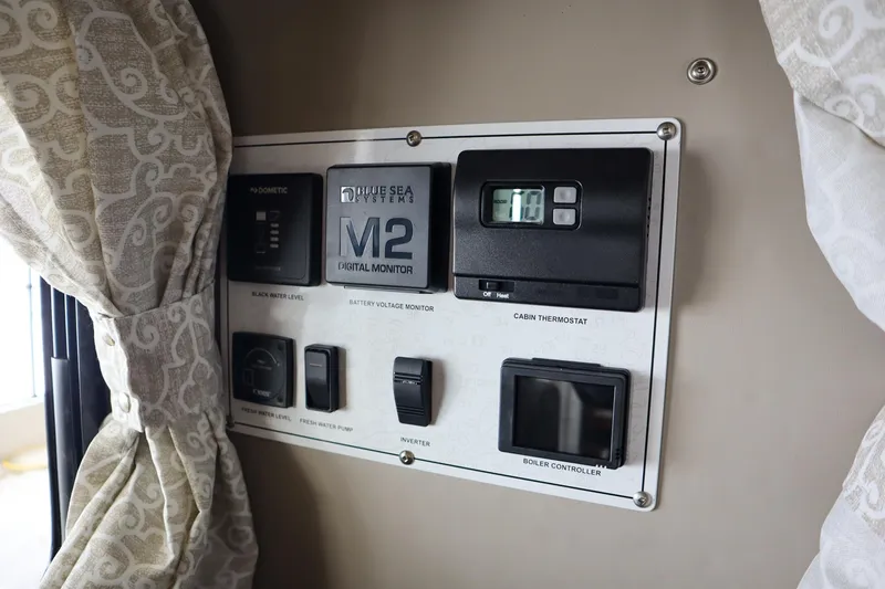 Slide: The Image of Control panel inside 2025 Hewescraft 290 Adventure ET HT boat, featuring various switches and displays. - 30