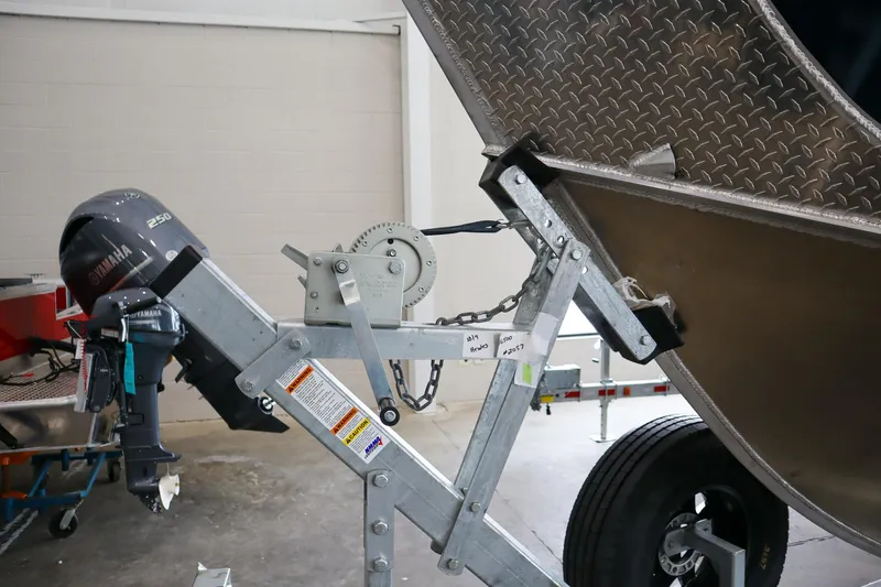 Slide: The Image of 2025 Hewescraft 290 Adventure ET HT boat trailer with motor in a garage setting. - 48