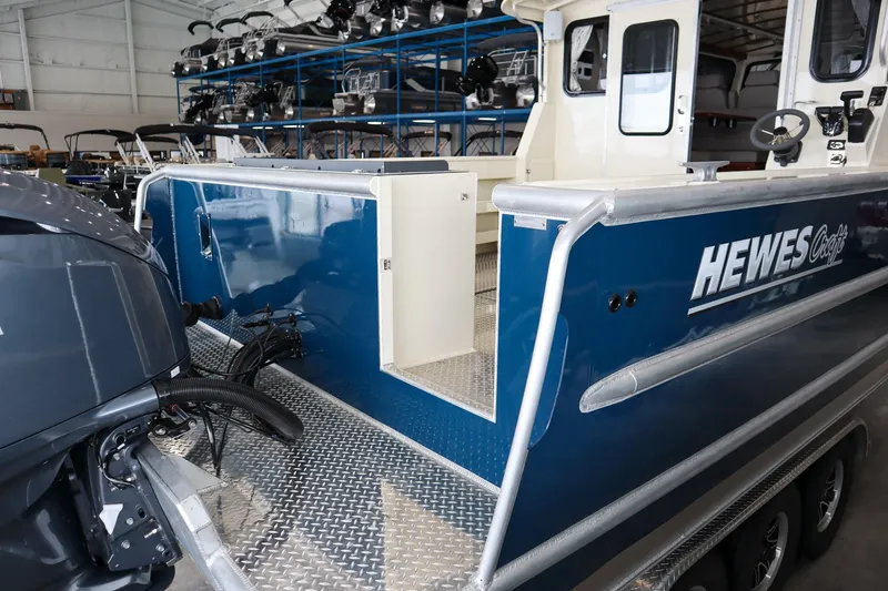 Slide: The Image of 2025 Hewescraft 290 Adventure ET HT boat, blue exterior, in a showroom setting. - 5