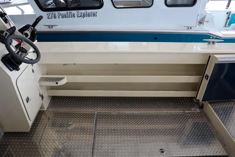 Slide: The Image of 2025 Hewescraft 290 Adventure ET HT boat interior with steering wheel and metal flooring. - 9