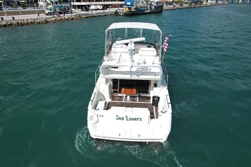 Slide: The Image of Azimut 43 yacht from 1997 named "Sea Lovers" cruising in clear blue waters. - 13