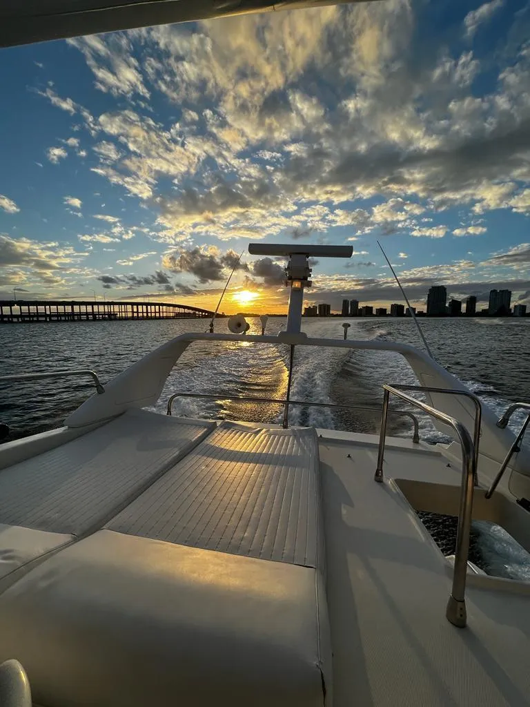 Slide: The Image of Azimut 43 yacht cruising at sunset, 1997 model, with scenic skyline and bridge view. - 19