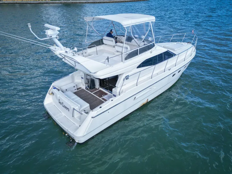 Slide: The Image of Azimut 43 yacht from 1997 on calm water, featuring a spacious deck and sleek design. - 2