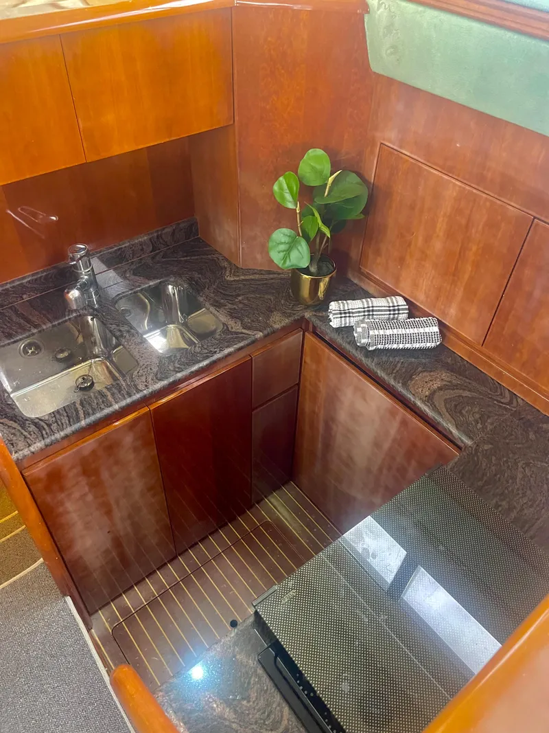 Slide: The Image of Luxurious kitchen interior of a 1997 Azimut 43 yacht with wood cabinetry and marble countertops. - 22