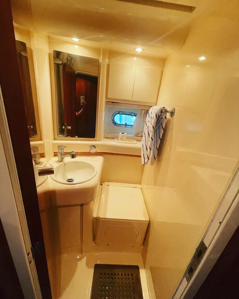 Slide: The Image of Bathroom interior of 1997 Azimut 43 yacht with sink, mirror, and porthole window. - 23