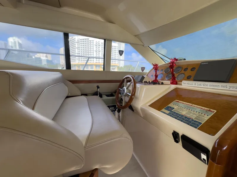 Slide: The Image of Interior of a 1997 Azimut 43 yacht with leather seating and wooden steering wheel. - 34