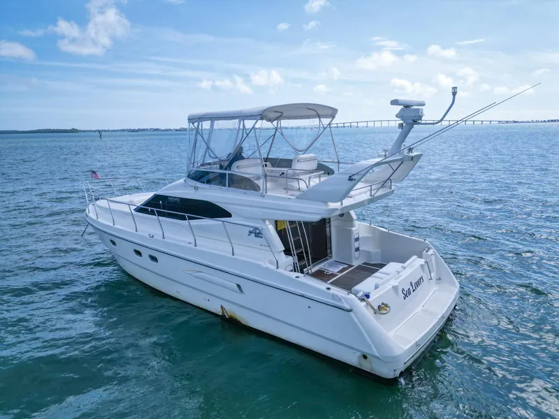 Slide: The Image of 1997 Azimut 43 yacht on open water under clear blue sky. - 43