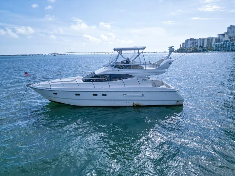 Slide: The Image of Azimut 43 yacht from 1997 on calm waters with cityscape background. - 44