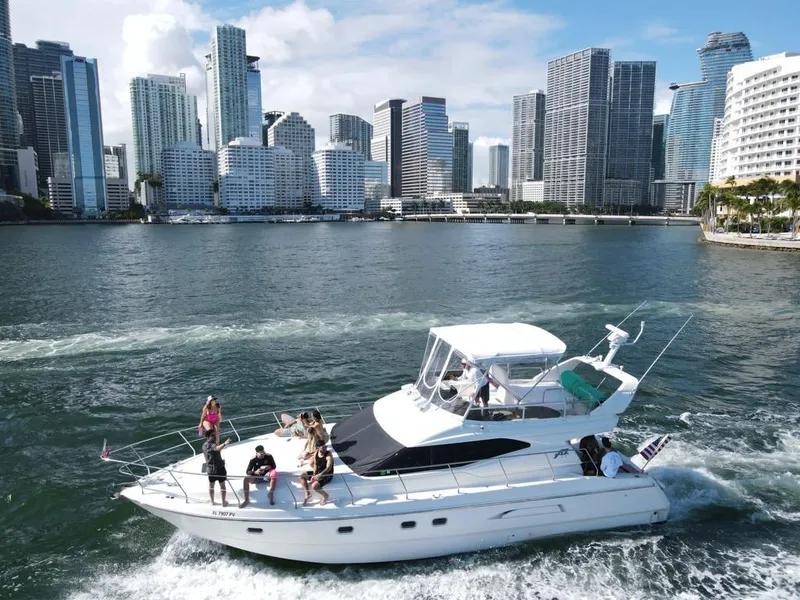 Slide: The Image of Azimut 43 yacht cruising near city skyline, 1997 model, with people enjoying the ride. - 8