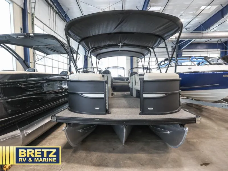 Slide: The Image of 2023 Cabrio 24UC pontoon boat in showroom, featuring spacious seating and canopy. - 3